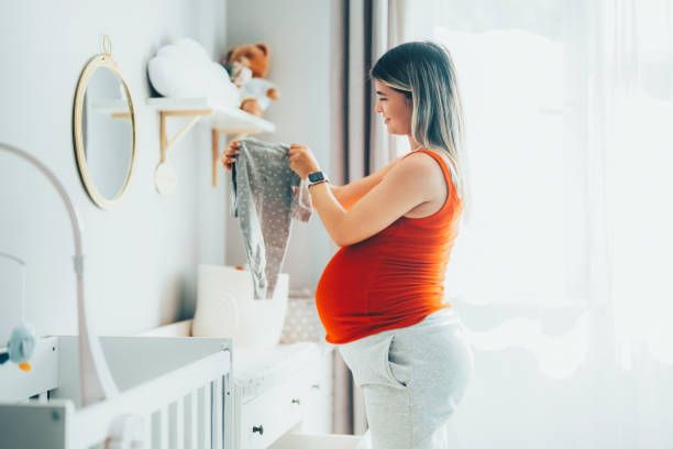 Young woman enjoying the last month of her pregnancy embarazada cuarto bebe agosto